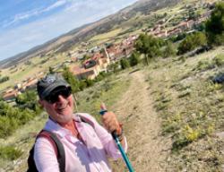 El periodista Carlos Herrera en el Camino del Cid con Santo Domingo de Silos al fondo